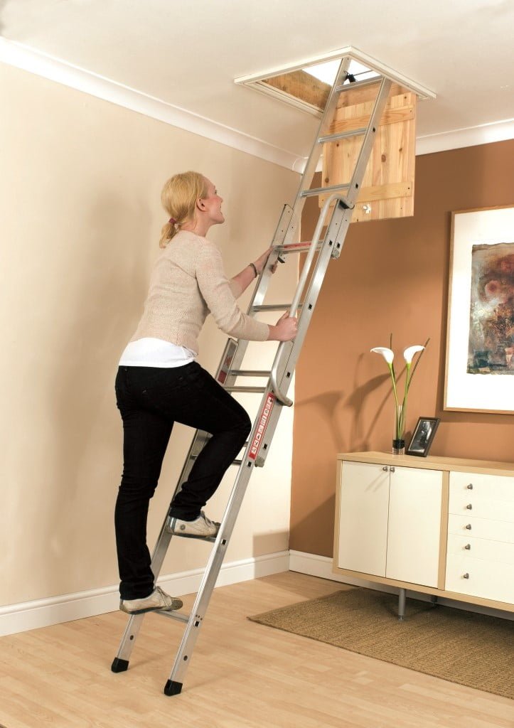 woman climbing loft ladder to access loft