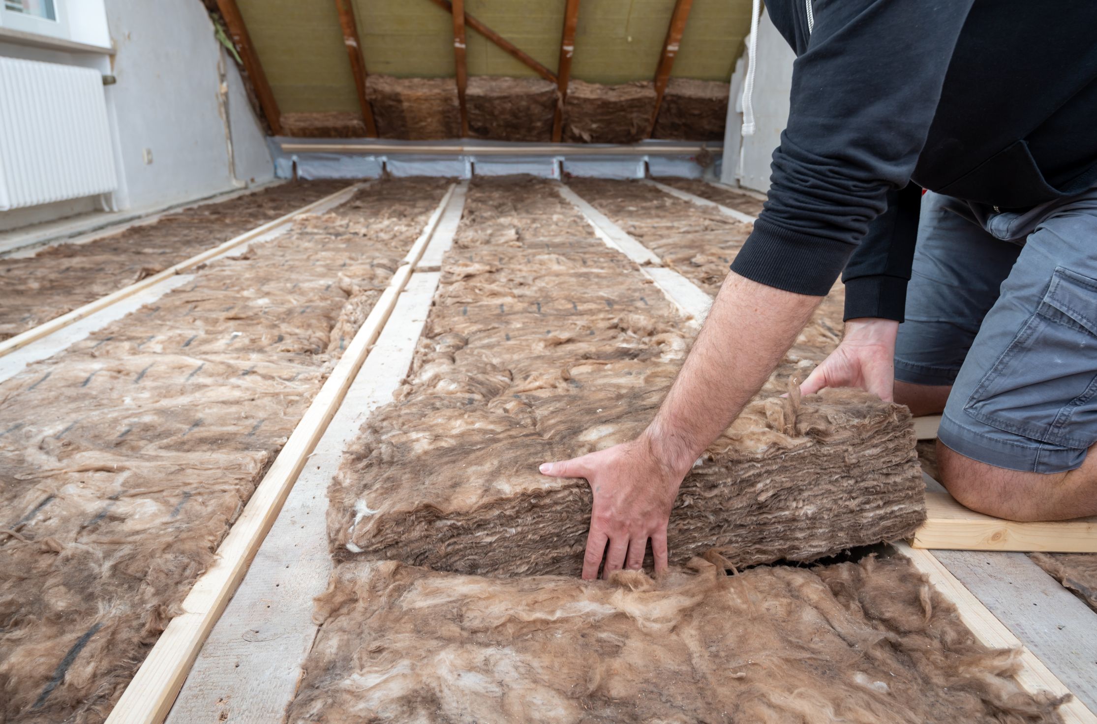 man fitting insulation to save energy